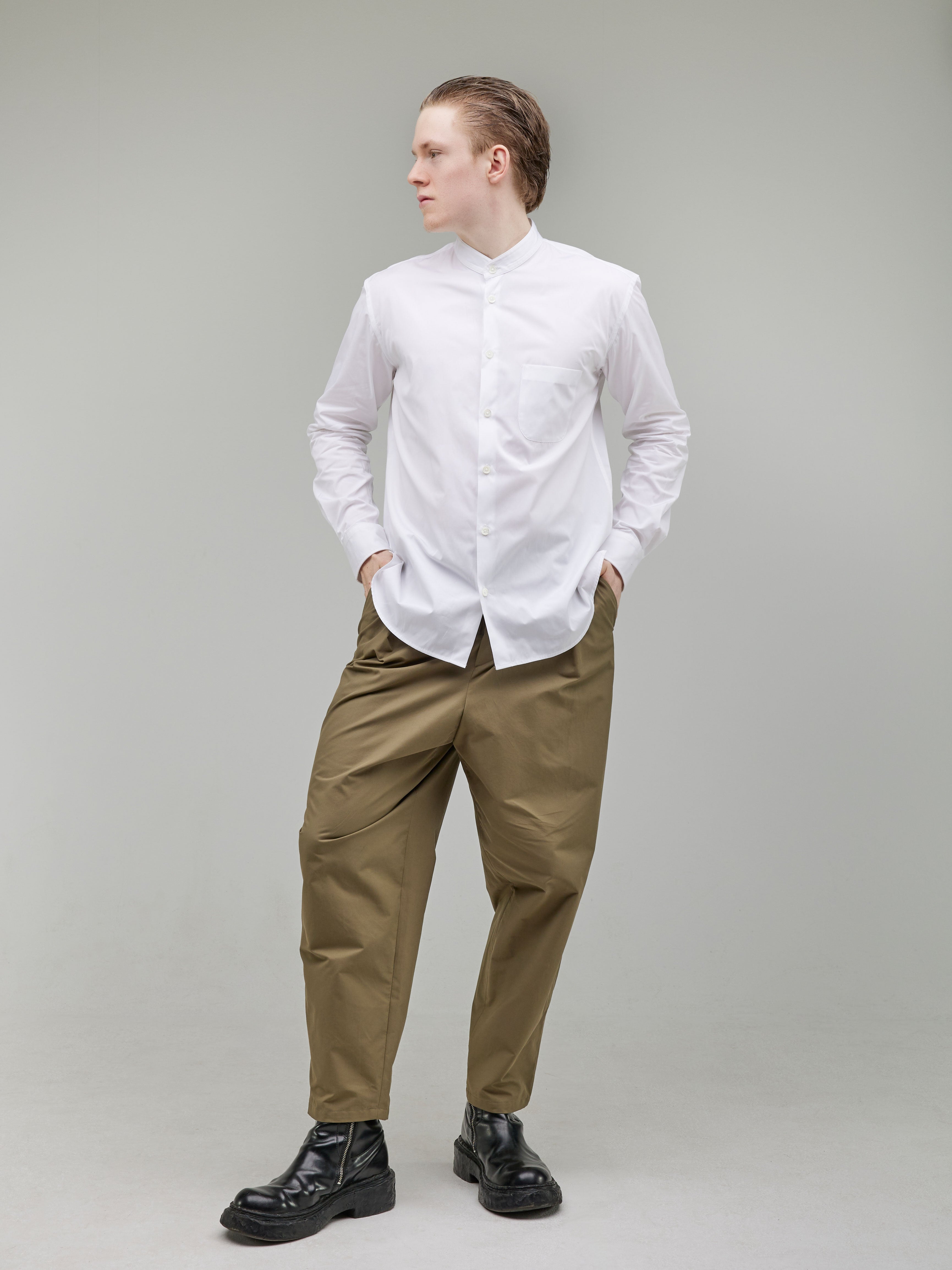 Tapered trousers with a rounded leg, featuring front pleats and a tailored waistband with button closure.
White Mao collar shirt