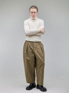 Wide-leg pleated trousers with an elastic waistband for adaptable comfort.