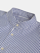 Close-up of a blue and white striped POCKETPARACHUTE® Shirt with Mao collar by gabrielstunz, showcasing its neatly buttoned design. The evenly spaced vertical stripes offer a classic, clean aesthetic, while elegant mother-of-pearl buttons add a touch of sophistication.