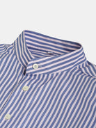 Close-up of an Oversized Mao Collar Shirt by gabrielstunz, featuring light blue with pink vertical stripes. Crafted from premium fabric, it showcases a contemporary design with a mao collar and three visible white buttons on the front. The neatly pressed fabric ensures the matching stripes on the collar stand out elegantly.