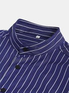 A close-up of the gabrielstunz Oversize Mao Collar Shirt in navy with white pinstripes showcases its XL size. The shirt features a stand collar, black buttons, and a luxurious fabric that looks smooth to the touch, providing a relaxed oversized fit.