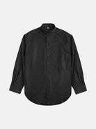 An oversized cotton shirt by gabrielstunz, colored in black with long sleeves and a left-side pocket. Expertly crafted from premium cotton, it is displayed flat on a white background, highlighting its rounded hem and subtle collar that exemplify European craftsmanship.