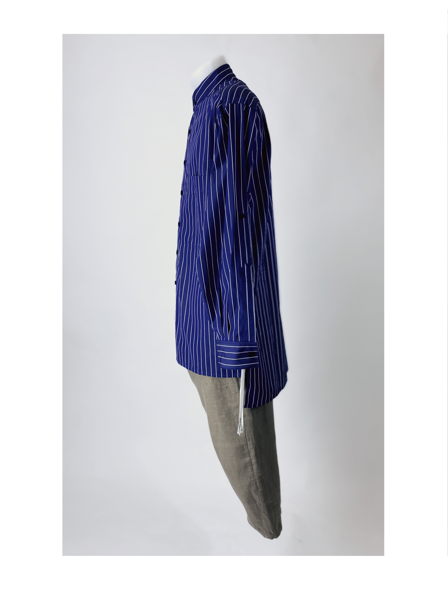 A mannequin torso dressed in a dark blue striped shirt paired with light gray pants, displayed from the side view against a plain white background.