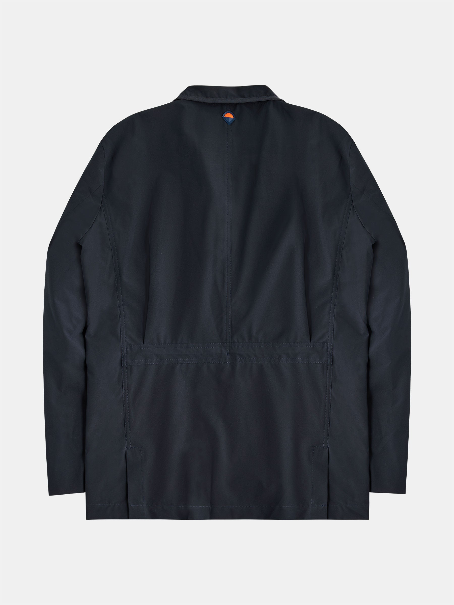 A navy-colored, long-sleeve Original POCKETPARACHUTE® Travel Blazer from gabrielstunz is displayed from the back. It features a minimalist design with a small circular emblem near the collar. The water-repellent blazer boasts a straight cut, subtle stitching details, and a packable design for convenience.