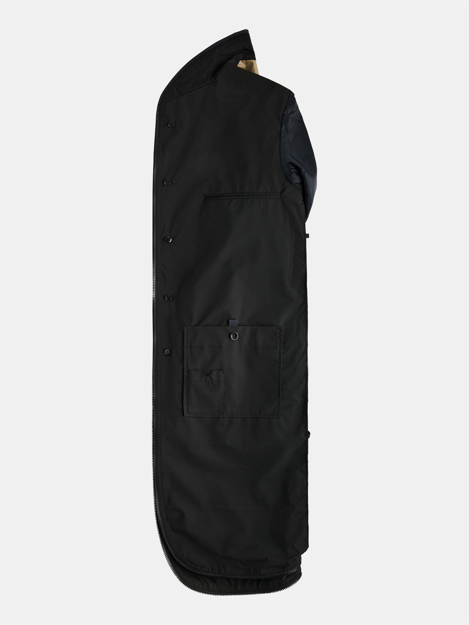 The POCKETPARACHUTE® Raincoat by gabrielstunz is a neatly folded, packable black piece with buttons along one side, featuring a small flap pocket near the center and a curved bottom edge. Its sleek design suggests water-repellent features, all displayed against a plain white background.