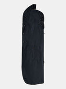 A black POCKETPARACHUTE® Tech Raincoat by gabrielstunz, designed with buttons for closure, is laid flat on a white background. It features a front pocket and a curved bottom edge, specifically designed for storing and protecting clothing. Its innovative fabric offers packable convenience, making it an ideal choice for travel.