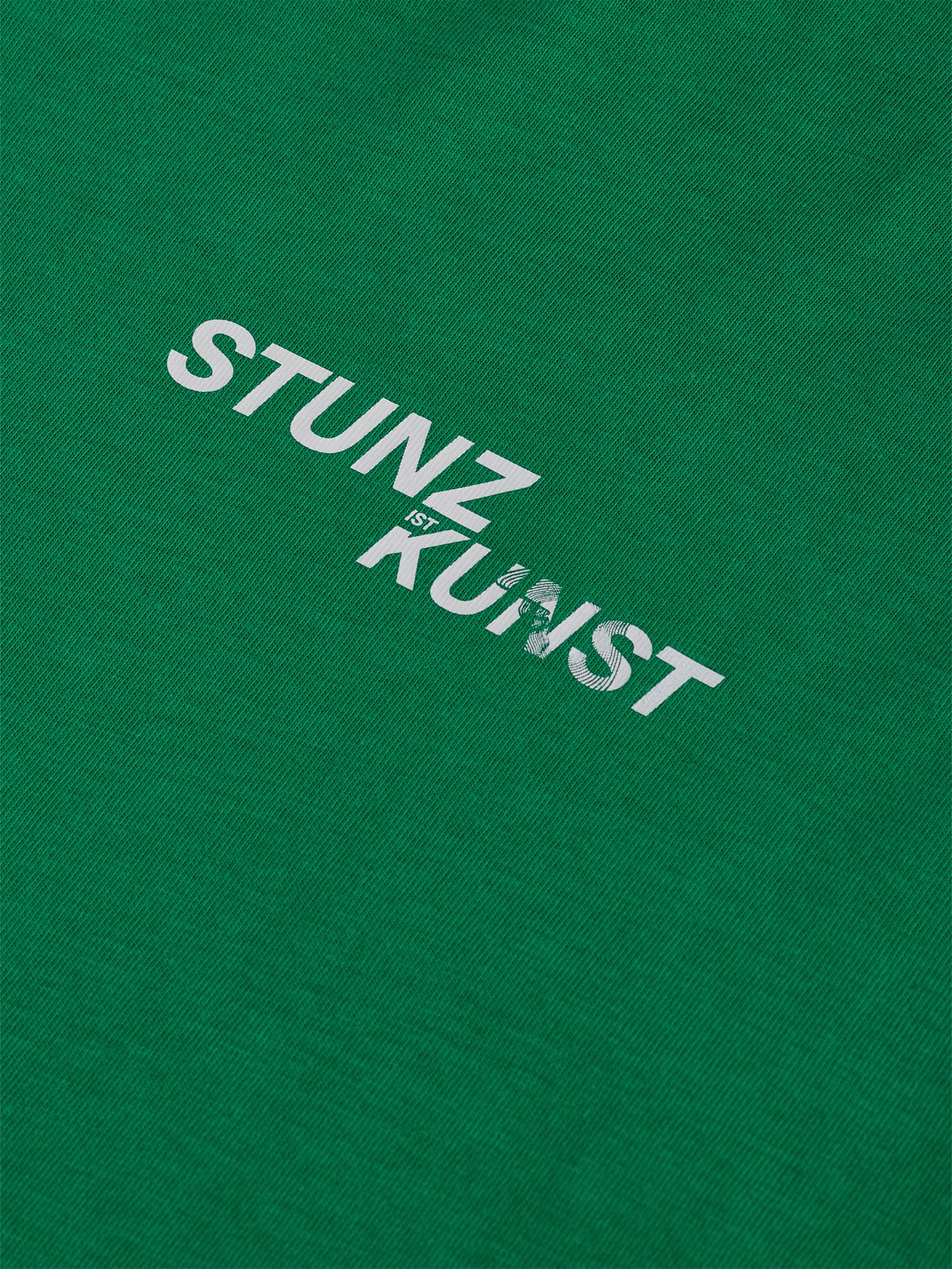 The gabrielstunz STUNZISTKUNST Edition T-Shirt features the bold white text "STUNZ KUNST" printed prominently on a vibrant green background. Crafted from sustainable, organic cotton, this simple yet impactful piece seamlessly combines style with eco-consciousness.